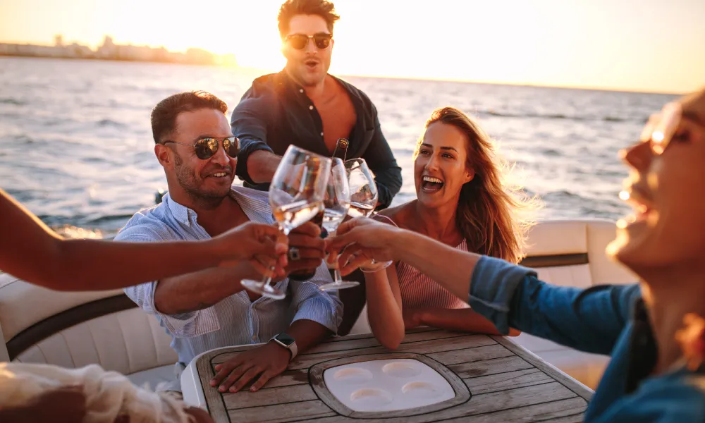 Friends toasting with drinks during a yacht party in Dubai