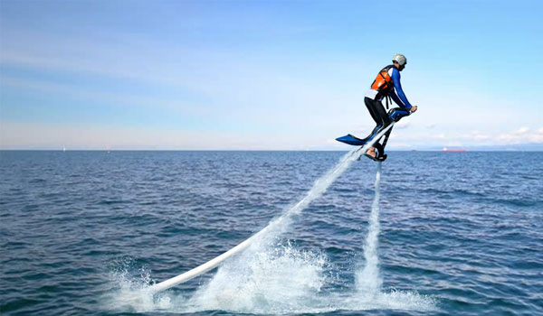 Boy flying like a superhero with flyboard watersports in Dubai